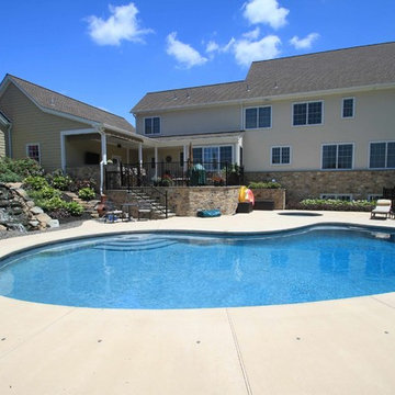 Kidney shaped in-ground salt water pool with outdoor kitchen