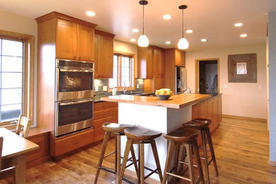 Transitional galley eat-in kitchen photo in Other with recessed-panel cabinets, medium tone wood cabinets, soapstone countertops and an island