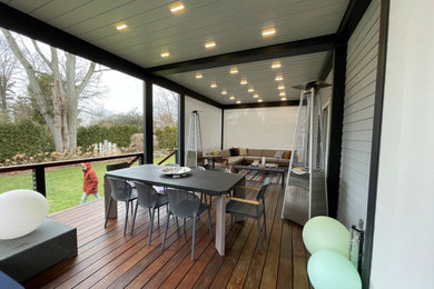 Inspiration for a large modern porch remodel in New York with decking and a pergola