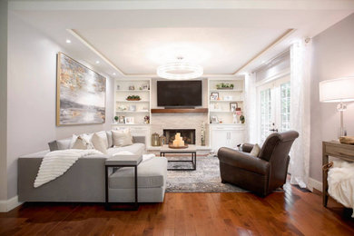 Example of a transitional medium tone wood floor living room design in Little Rock with a wall-mounted tv