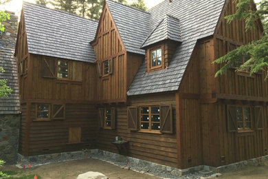 Example of a large mountain style brown two-story wood exterior home design in Other with a shingle roof