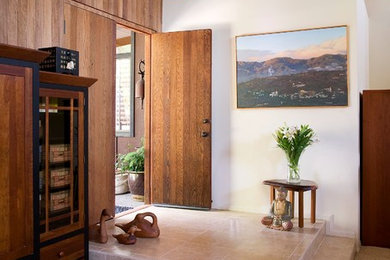 Mid-sized 1960s travertine floor entryway photo in Santa Barbara with white walls and a dark wood front door