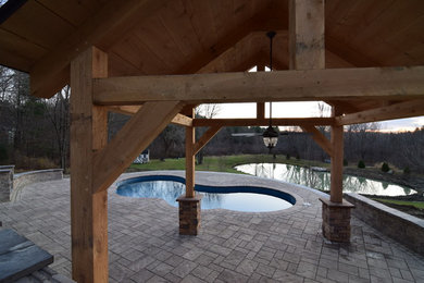 Inspiration for a large backyard concrete paver and custom-shaped water slide remodel in Boston