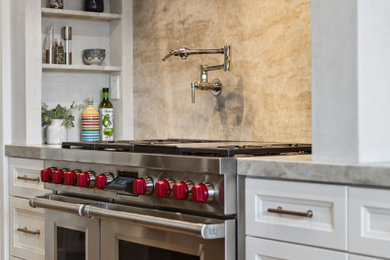 Example of a transitional medium tone wood floor and tray ceiling kitchen design in San Francisco with shaker cabinets, white cabinets, quartzite countertops, stone slab backsplash and an island