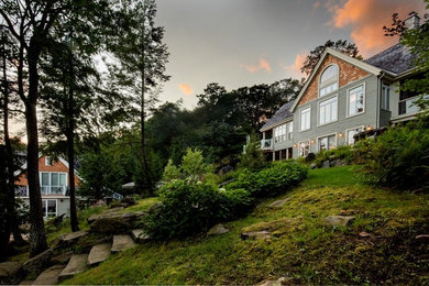 Large mountain style green two-story mixed siding exterior home photo in Toronto with a shingle roof