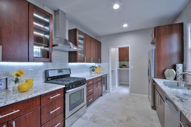 Inspiration for a mid-sized transitional galley separate kitchen in San Francisco with an undermount sink, flat-panel cabinets, dark wood cabinets, granite benchtops, white splashback, subway tile splashback, stainless steel appliances, porcelain floors, no island, beige floor and grey benchtop.