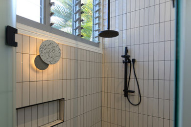 Inspiration for a mid-sized beach style master wet room bathroom in Sunshine Coast with white tile, ceramic tile, white walls, travertine floors, a hinged shower door and vaulted.