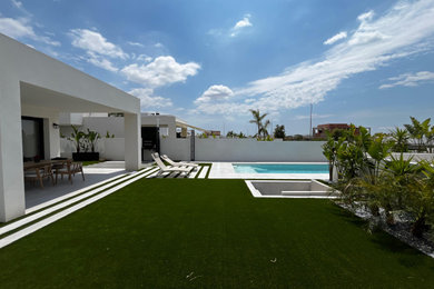 Diseño de acceso privado mediterráneo grande en verano en patio con camino de entrada, exposición total al sol y adoquines de hormigón