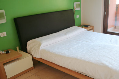 Ejemplo de habitación de invitados retro con paredes verdes y suelo de baldosas de cerámica