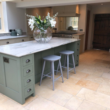 Green kitchen with large island, larder top and white quartzite worktops