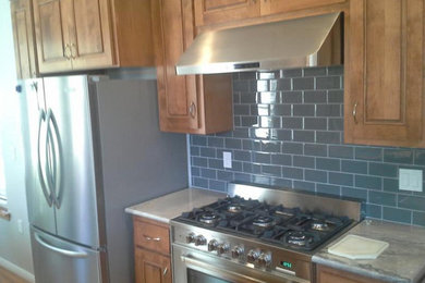 Inspiration for a light wood floor kitchen remodel in Austin with light wood cabinets, granite countertops, blue backsplash, subway tile backsplash and stainless steel appliances