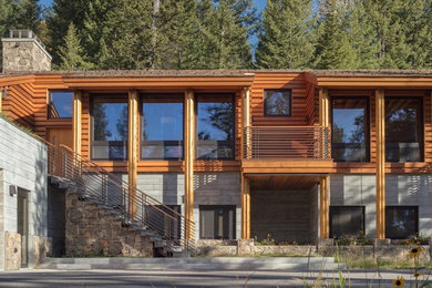 Inspiration for a large modern brown two-story wood exterior home remodel in Other with a green roof