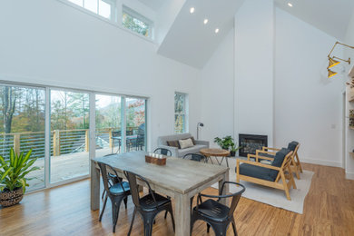 Living room - small transitional open concept brown floor and bamboo floor living room idea in Other with white walls and a standard fireplace