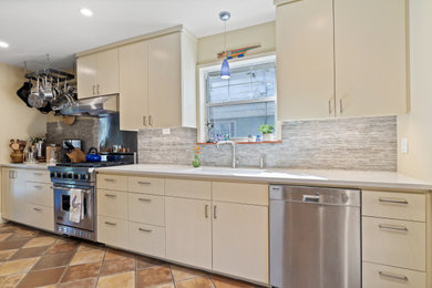 Example of a mid-sized eclectic galley terra-cotta tile eat-in kitchen design in Dallas with an undermount sink, flat-panel cabinets, beige cabinets, quartz countertops, glass tile backsplash, stainless steel appliances, no island and white countertops
