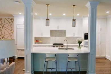 Inspiration for a mid-sized transitional l-shaped brown floor and dark wood floor kitchen remodel in Charlotte with an undermount sink, shaker cabinets, white cabinets, marble countertops, white backsplash, glass tile backsplash, paneled appliances and an island