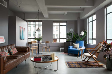 Inspiration for a mid-sized industrial formal open concept living room in Los Angeles with grey walls, concrete floors, no fireplace, no tv and grey floor.