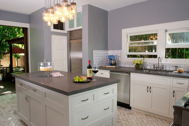 Mid-sized arts and crafts l-shaped marble floor kitchen photo in Los Angeles with an undermount sink, shaker cabinets, white cabinets, soapstone countertops, white backsplash, subway tile backsplash, stainless steel appliances and an island