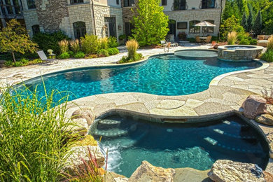 Example of a mid-sized classic backyard stamped concrete and custom-shaped natural hot tub design in Chicago