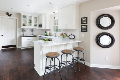Inspiration for a mid-sized transitional u-shaped dark wood floor eat-in kitchen remodel in Milwaukee with an undermount sink, recessed-panel cabinets, white cabinets, granite countertops, white backsplash, ceramic backsplash and stainless steel appliances