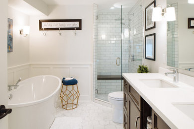 Mid-sized country master bathroom in Vancouver with shaker cabinets, dark wood cabinets, a freestanding tub, a corner shower, a two-piece toilet, white tile, porcelain tile, white walls, porcelain floors, an undermount sink, engineered quartz benchtops, grey floor and a hinged shower door.