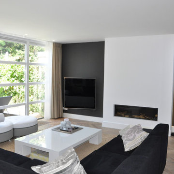 Conception de salon avec cheminée et paroi vitrée vers le jardin