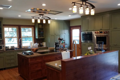 Example of a large arts and crafts medium tone wood floor kitchen design in Los Angeles with shaker cabinets, green cabinets, stainless steel appliances and two islands