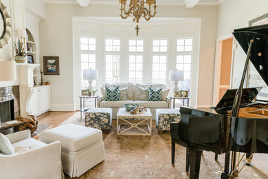 Inspiration for a mid-sized timeless medium tone wood floor and brown floor living room remodel in Other with beige walls, a standard fireplace and a tile fireplace