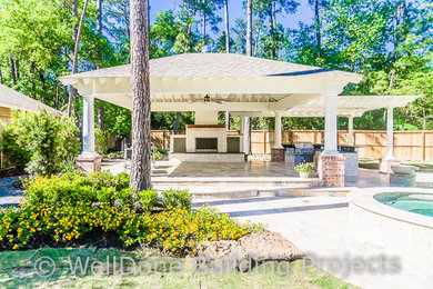 Inspiration for a large coastal backyard stone patio kitchen remodel in Houston with a gazebo