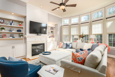 Inspiration for a mid-sized transitional open concept family room in Raleigh with grey walls, medium hardwood floors, a standard fireplace, a tile fireplace surround and a wall-mounted tv.
