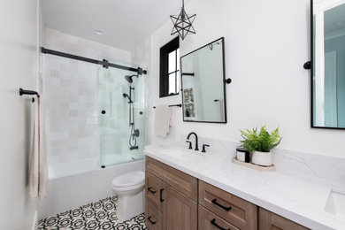 Example of a minimalist kids' ceramic tile, multicolored floor and double-sink bathroom design in Orange County with shaker cabinets, light wood cabinets, white walls, an undermount sink, quartz countertops, white countertops and a built-in vanity