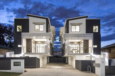 Modern townhouse exterior in Brisbane with mixed siding, a flat roof and a metal roof.