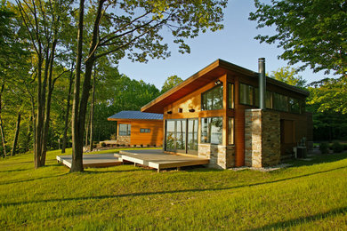 Inspiration for a large modern brown two-story mixed siding house exterior remodel in Philadelphia with a shed roof and a metal roof