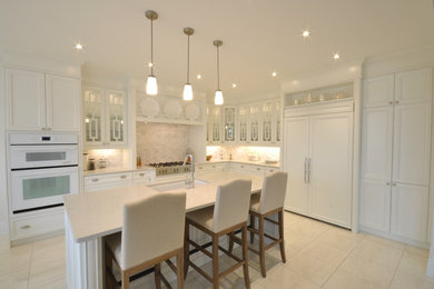 Photo of a contemporary kitchen in Ottawa with recessed-panel cabinets, white cabinets, white splashback, white appliances and with island.