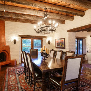 アルバカーキの広いサンタフェスタイルのLDKの画像 (白い壁、テラコッタタイルの床、コーナー設置型暖炉、漆喰の暖炉まわり)