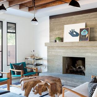 Idéer för ett modernt vardagsrum, med vita väggar, en standard öppen spis och en spiselkrans i betong