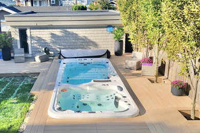 Example of a mid-sized trendy backyard ground level deck design in Vancouver with no cover