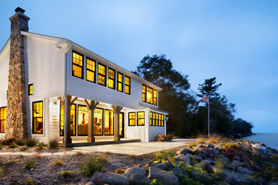 Exemple d'une façade de maison blanche chic en planches et couvre-joints à un étage avec un toit à deux pans, un toit en shingle, un toit marron et un revêtement mixte.
