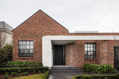 Photo of a large contemporary two-storey brick house exterior in Melbourne with a metal roof.
