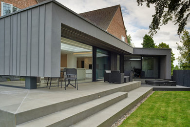 This is an example of a medium sized contemporary back ground level terrace in West Midlands with a roof extension.