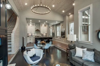 Family room - small cottage open concept concrete floor and black floor family room idea in Nashville with gray walls, a media wall and no fireplace