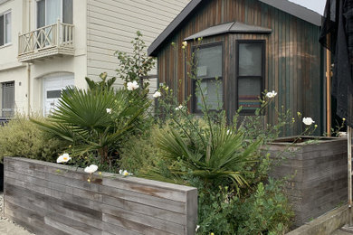 This is an example of a mid-sized contemporary full sun concrete paver and wood fence landscaping in San Francisco.