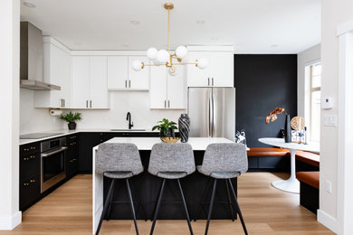 Photo of a small modern l-shaped open plan kitchen in Vancouver with a submerged sink, shaker cabinets, black cabinets, engineered stone countertops, white splashback, engineered quartz splashback, stainless steel appliances, vinyl flooring, an island and white worktops.