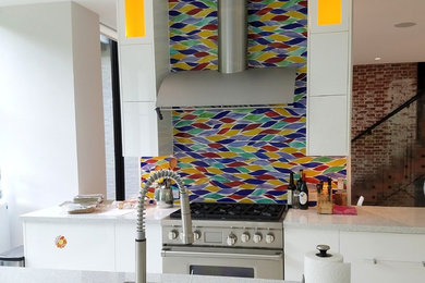 Example of a trendy kitchen design in Baltimore with an undermount sink, flat-panel cabinets, white cabinets, mosaic tile backsplash and paneled appliances