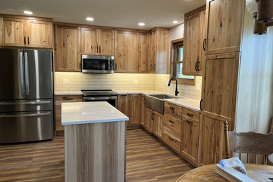 Eat-in kitchen - mid-sized traditional l-shaped eat-in kitchen idea in Other with shaker cabinets, light wood cabinets, quartz countertops, white backsplash and an island