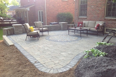 This is an example of a mid-sized traditional backyard patio in Louisville with concrete pavers and no cover.