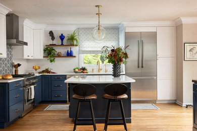ニューヨークにある高級な中くらいなトランジショナルスタイルのおしゃれなキッチン (シングルシンク、フラットパネル扉のキャビネット、青いキャビネット、珪岩カウンター、青いキッチンパネル、モザイクタイルのキッチンパネル、シルバーの調理設備、淡色無垢フローリング、茶色い床、黄色いキッチンカウンター) の写真