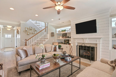 Inspiration for a large transitional open concept dark wood floor living room remodel in Charleston with gray walls, a standard fireplace, a stone fireplace and a wall-mounted tv