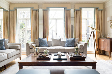 Large classic formal enclosed living room in London with beige walls, medium hardwood flooring and brown floors.