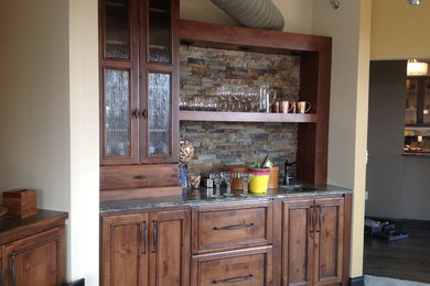 Example of a small mountain style single-wall carpeted wet bar design in Milwaukee with an undermount sink, recessed-panel cabinets, dark wood cabinets and granite countertops