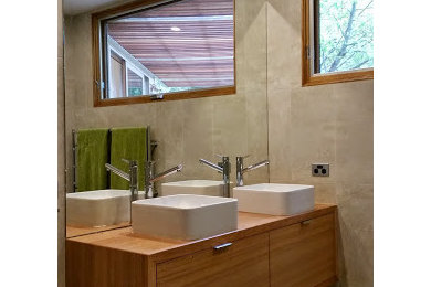This is an example of a mid-sized contemporary master bathroom in Melbourne with light wood cabinets, an open shower, gray tile, porcelain tile, porcelain floors and wood benchtops.